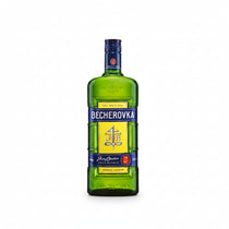 Front view of a green bottle of Becherovka herbal liqueur with a yellow and blue label.